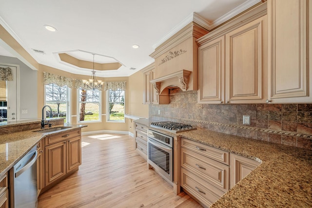kitchen with an inviting chandelier, a tray ceiling, visible vents, a sink, and stainless steel appliances