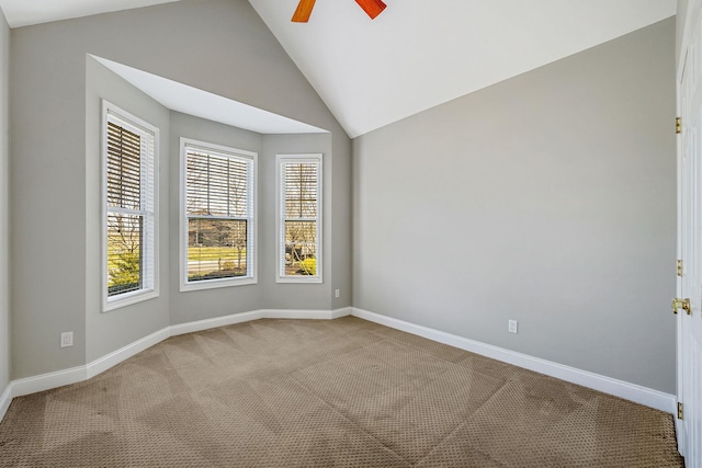 carpeted empty room featuring baseboards, a ceiling fan, and vaulted ceiling