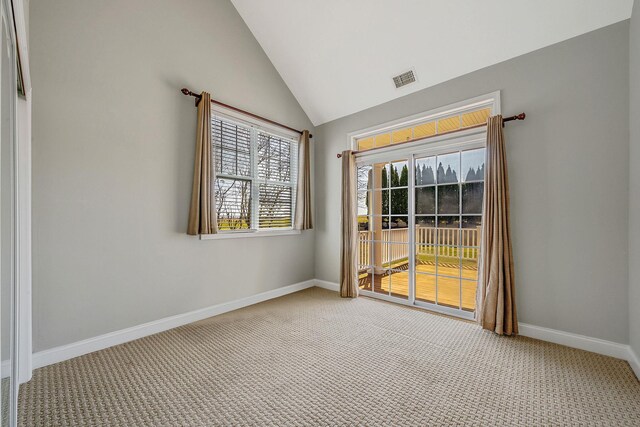 carpeted empty room featuring visible vents, baseboards, and vaulted ceiling