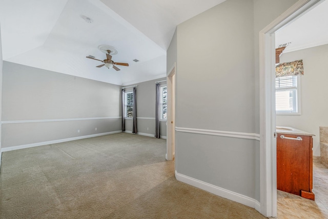 unfurnished room with visible vents, baseboards, a ceiling fan, vaulted ceiling, and light colored carpet