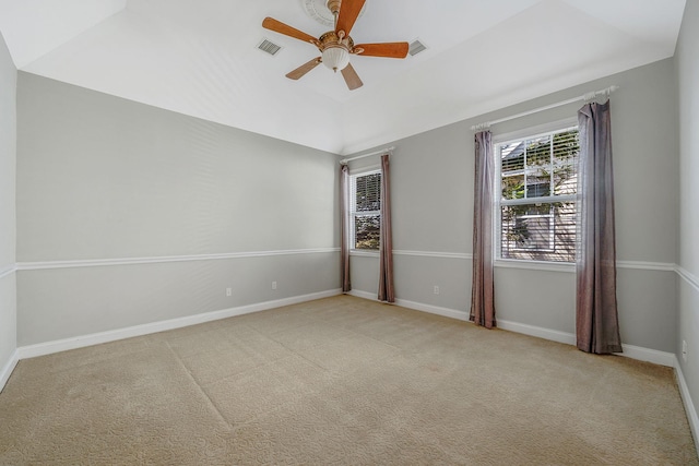 carpeted spare room with baseboards, lofted ceiling, a ceiling fan, and visible vents
