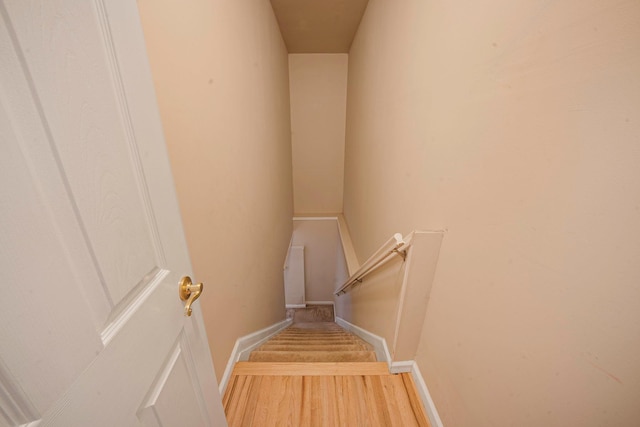 stairway with wood finished floors and baseboards