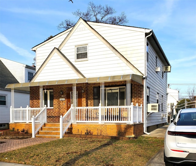 bungalow-style home featuring cooling unit, brick siding, and covered porch