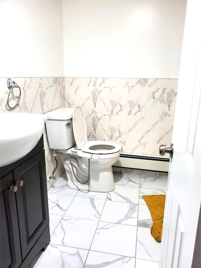 bathroom with a wainscoted wall, toilet, marble finish floor, vanity, and a baseboard radiator