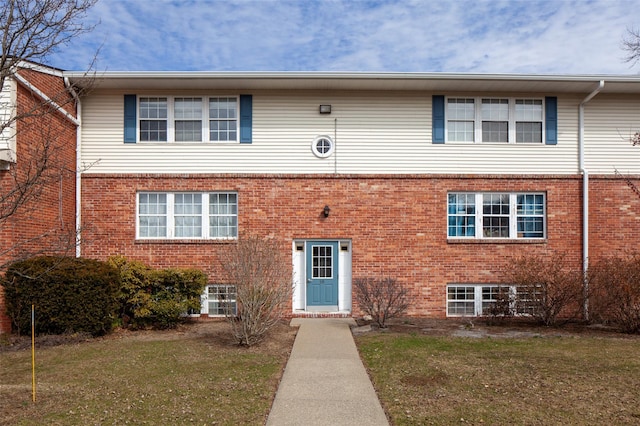 view of front of home with a front lawn and brick siding