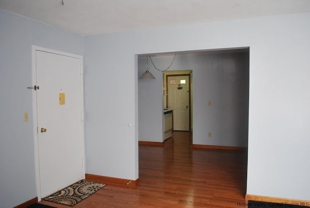 empty room with baseboards and wood finished floors