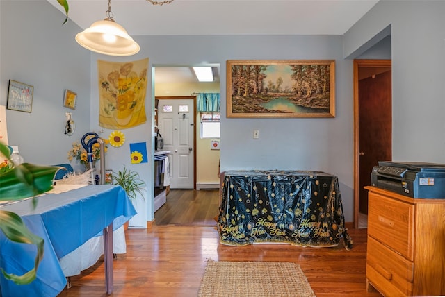 entrance foyer with wood finished floors and a baseboard radiator