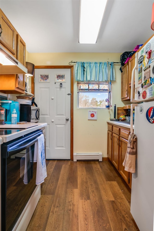 kitchen with electric stove, brown cabinets, freestanding refrigerator, and a baseboard radiator