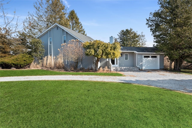 view of front of property featuring stucco siding, a front lawn, driveway, an attached garage, and a chimney