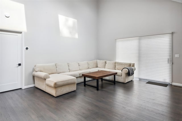 living room with baseboards and dark wood-style flooring