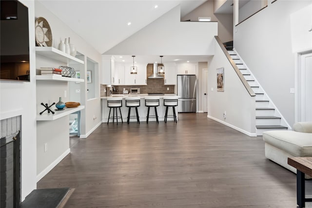 living room with baseboards, stairs, recessed lighting, dark wood-style floors, and high vaulted ceiling