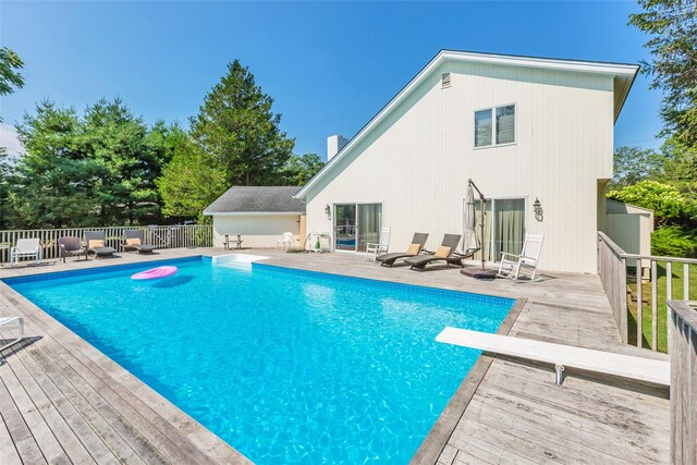 view of pool with a fenced in pool, a diving board, a patio, and fence