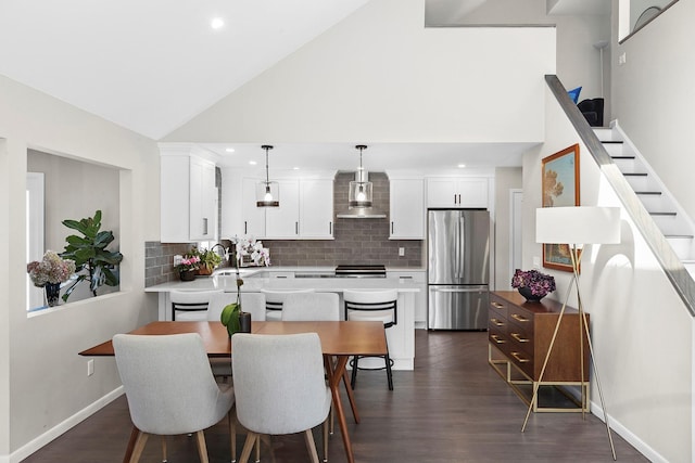 dining room featuring dark wood finished floors, baseboards, high vaulted ceiling, and recessed lighting