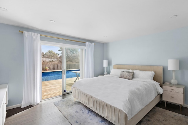 bedroom featuring baseboards, access to exterior, and wood finished floors