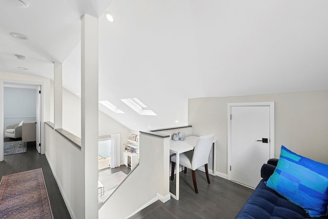 office space with dark wood-type flooring, vaulted ceiling with skylight, and baseboards