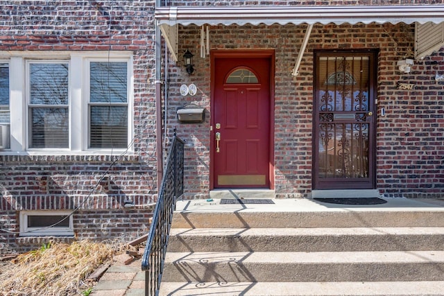 entrance to property featuring brick siding