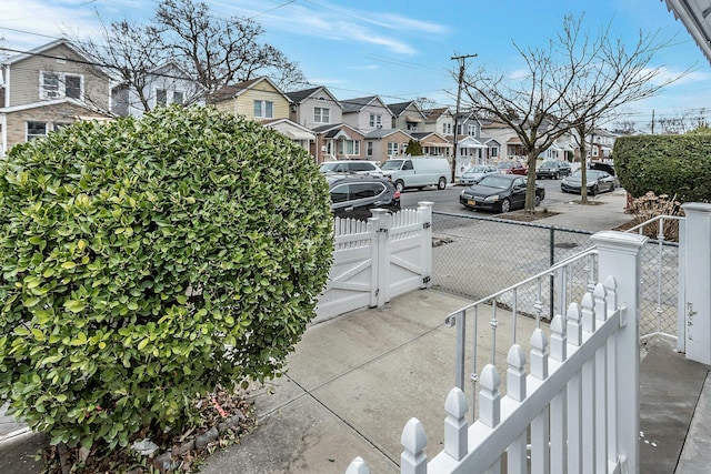 view of road featuring sidewalks, a gate, and a residential view