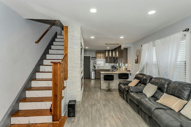 living room featuring stairway, recessed lighting, and light wood-type flooring