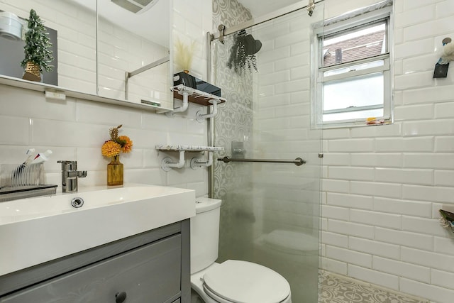 full bath with vanity, toilet, tile walls, and a shower stall