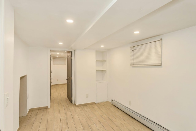 empty room with light wood-type flooring, a baseboard heating unit, baseboards, and recessed lighting