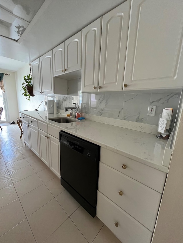 kitchen featuring black dishwasher, light tile patterned floors, white cabinetry, and a sink