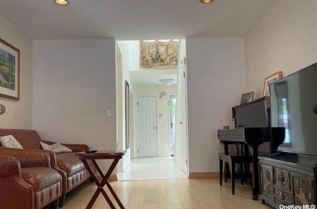 living room with recessed lighting, baseboards, and light wood-style floors
