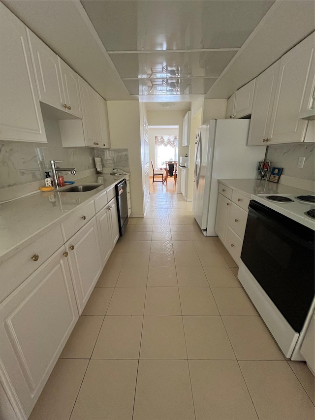 kitchen with electric stove, black dishwasher, light countertops, white cabinets, and a sink