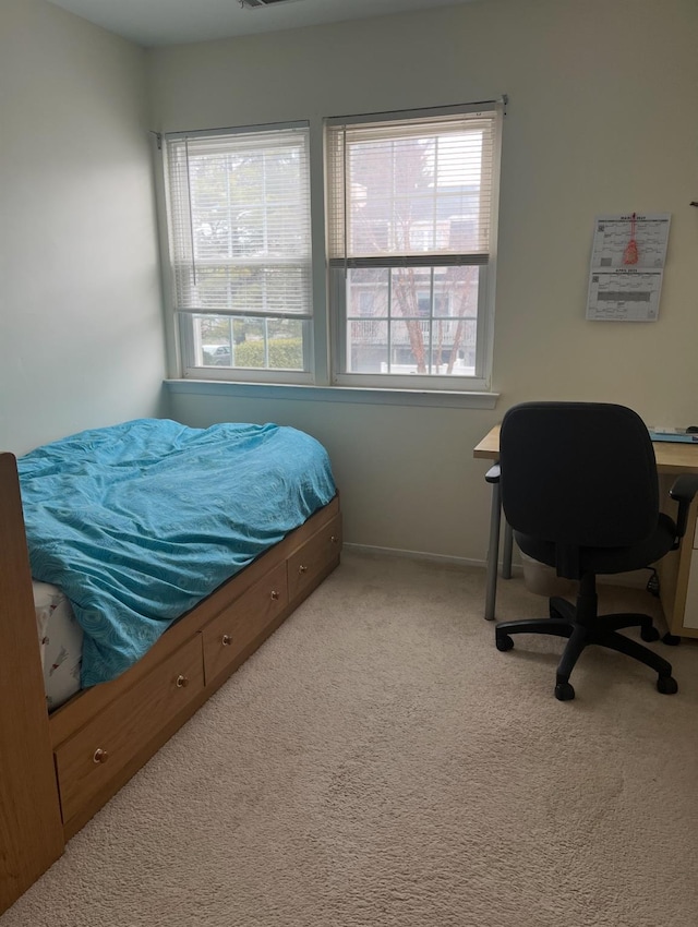 carpeted bedroom featuring baseboards and multiple windows