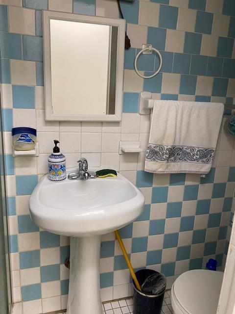 bathroom with backsplash, tile walls, tile patterned flooring, and toilet