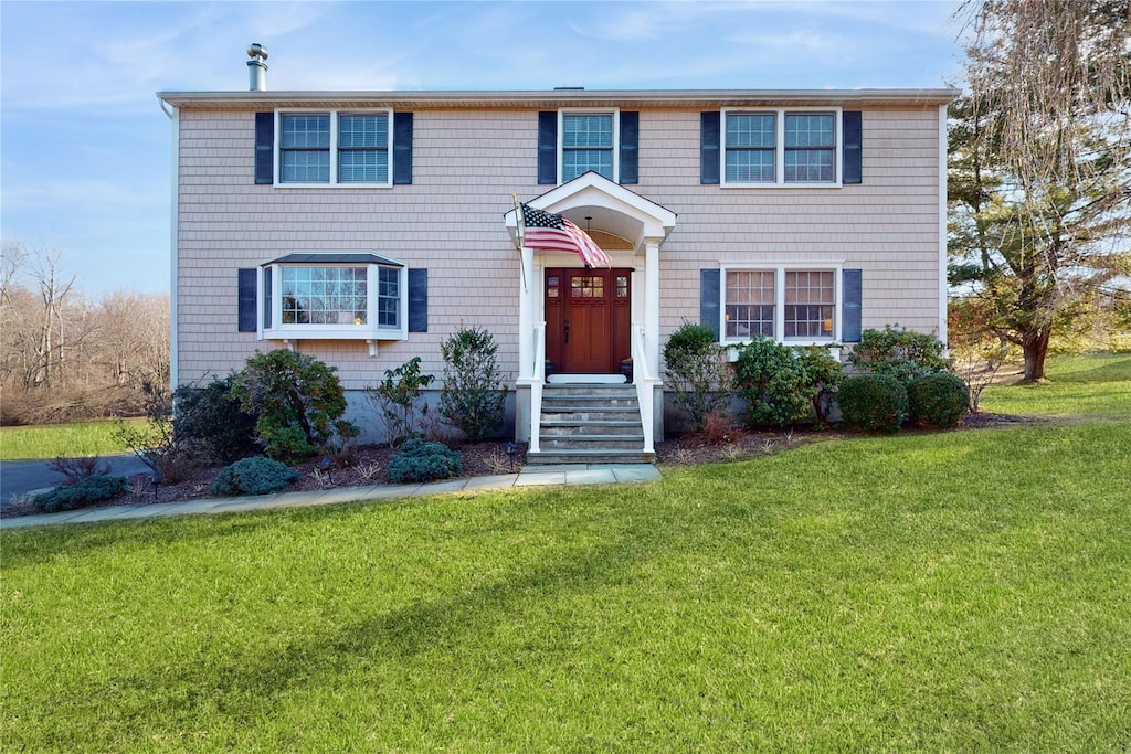 colonial inspired home featuring a front yard
