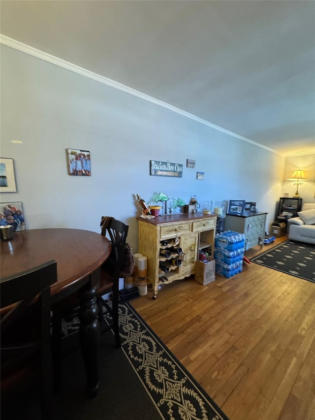 dining room with ornamental molding and wood finished floors