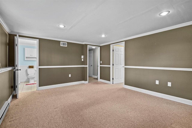 basement with ornamental molding, a baseboard heating unit, and light colored carpet