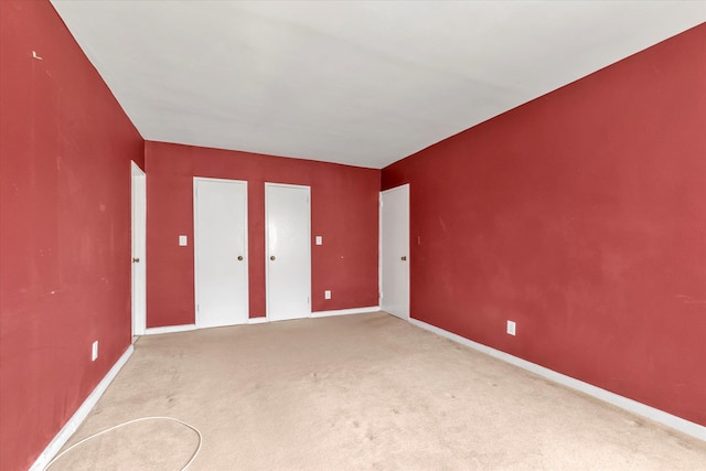 unfurnished room with baseboards and carpet floors