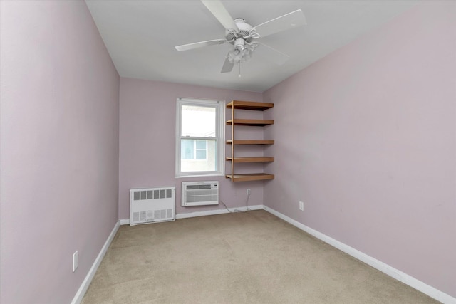 empty room featuring an AC wall unit, baseboards, light carpet, a ceiling fan, and radiator heating unit