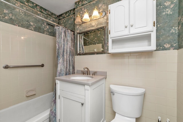 bathroom with vanity, wallpapered walls, toilet, shower / bath combo with shower curtain, and tile walls