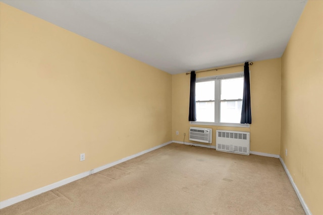 unfurnished room with radiator heating unit, a wall mounted AC, light colored carpet, and baseboards