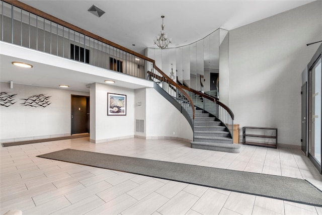 interior space with a towering ceiling, visible vents, recessed lighting, stairs, and a notable chandelier