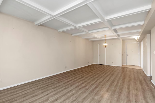 interior space with beam ceiling, baseboards, coffered ceiling, and wood finished floors