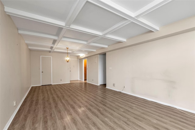 spare room featuring beamed ceiling, baseboards, coffered ceiling, and wood finished floors