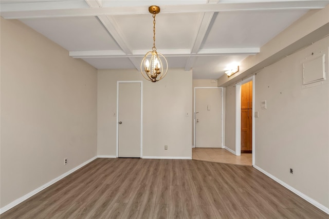 spare room with light wood finished floors, baseboards, an inviting chandelier, and beam ceiling