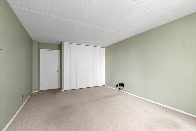 unfurnished bedroom featuring a closet, baseboards, and carpet