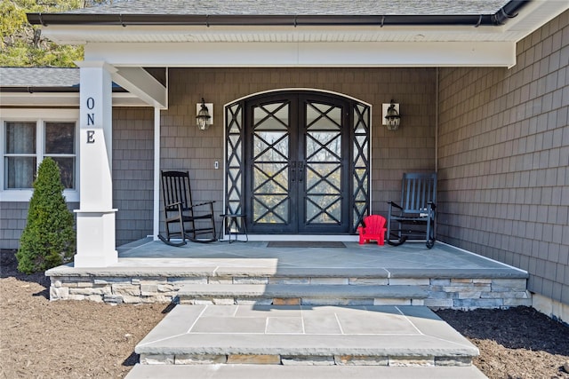 entrance to property featuring roof with shingles