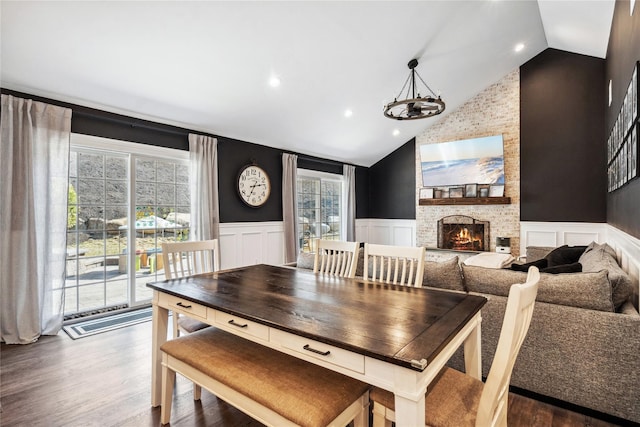 dining space with lofted ceiling, wainscoting, and dark wood-style flooring