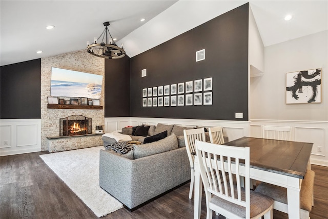 living room with visible vents, an inviting chandelier, lofted ceiling, and wood finished floors