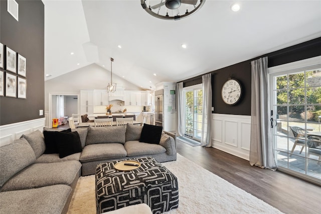 living area with dark wood-type flooring, a wealth of natural light, and wainscoting