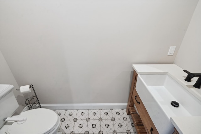 bathroom with vanity, toilet, and baseboards