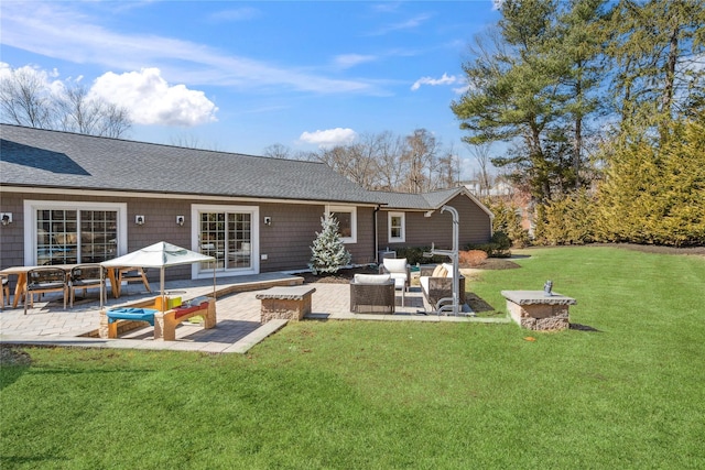 rear view of property with a patio, a lawn, outdoor lounge area, and a shingled roof