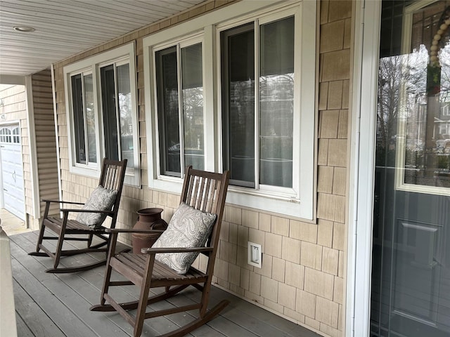 wooden terrace featuring a garage and a porch