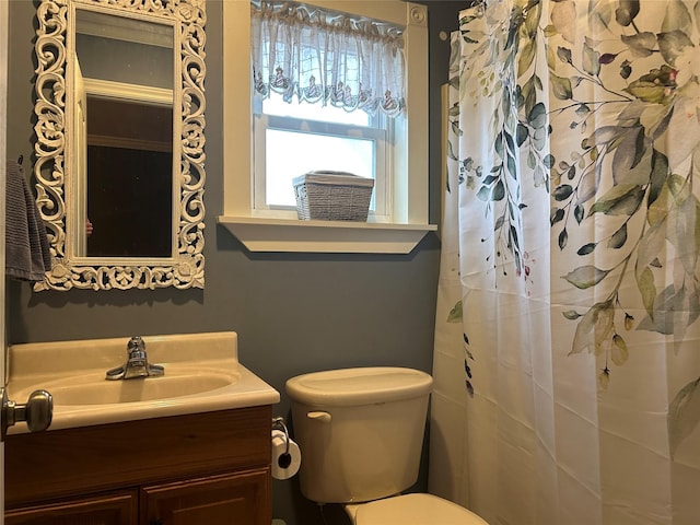 full bathroom featuring toilet, vanity, and a shower with curtain