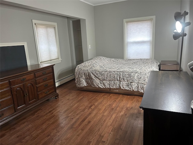 bedroom featuring dark wood finished floors, a baseboard heating unit, and ornamental molding